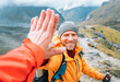 © Soloviova Liudmyla - Smiling backpacker dressed orange jacket giving High Five to female mate during Himalaya valley trekking. Mera peak climbing route near the Khare settlement, Makalu Barun National Park trek in Nepal.