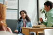 © pressmaster - Clever girl in eyeglasses and casualwear looking at one of classmates at break during discussion of new rules after English grammar lesson