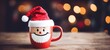 Christmas Saint Nicholas Day holiday celebration greeting card - Closeup of cup with Santa Claus hat on wooden table and bokeh lights in the background