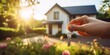© Ben - The Key to a New Beginning: A Hand Holding Keys in Front of a Modern New House with a Beautiful Garden, Embracing the Promise of a Fresh Start