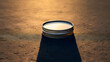 A minimalist shot of a SNUS can casting a long shadow in the evening light. 