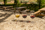 Fototapeta  - 3 kieliszki z winem stojące na kamienny stole. degustacja Porto w Portugalii