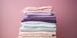 © AkimD - AI Generated. AI Generative. Fresh new washed laundy stack set of many cloth items on table. Graphic Art