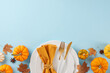 canvas print picture - Form a Thanksgiving table that makes an impression. Top view photo of plates, cutlery, pumpkins, anise, napkin, fallen leaves on light blue background with promo space
