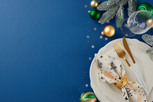 Setting The Stage: Your Christmas Table Preparation Guide. Top View Photo Of Cutlery, Plates, Glassware, Frost-kissed Fir Branches, Napkin, Balls, Silver Snowflakes On Blue Background With Promo Space