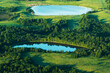 Forest lake, aerial view. View of small round lake in field near forest. Drone view of two round lakes. Location with lakes in wild. Freshwater lakes. panoramic wild landscape. Pond in rural landscape