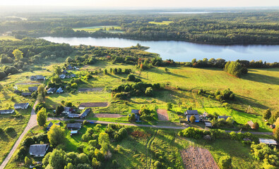 Wall Mural - Lake in rural on sunset, drone view. Rural landscape with village houses. Drink water safe. Global drought crisis. Country houses at lake. Farm field or farmland in Country. Village home at lake.