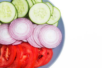 Wall Mural - Sliced vegetables on a plate. Red onion, red tomato and green cucumber. Dinner salad background. Healthy snack slices. Vegan diet on a plate. Isolated on white. Empty copy space.