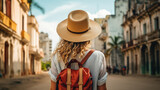 Fototapeta Uliczki - Tourist Woman with Hat and Backpack in XXX. Wanderlust concept.