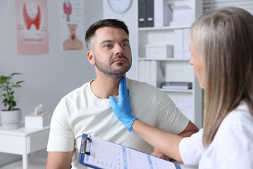 Endocrinologist examining thyroid gland of patient at hospital