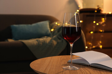 Sticker - Glass of red wine and open notebook on wooden table in room, space for text. Relax at home