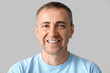 © Pixel-Shot - Portrait of happy mature man on grey background