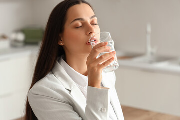 Poster - Beautiful young woman with drinking water in kitchen