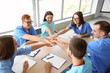 © Pixel-Shot - Group of medical students putting hands together at university