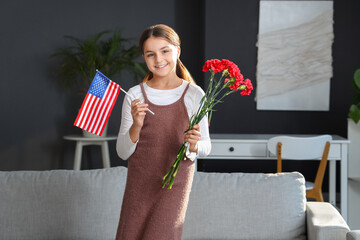 Wall Mural - Little girl with USA flag and flowers at home. Veterans Day celebration