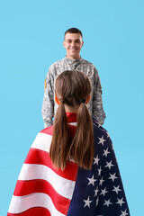 Wall Mural - Little girl with USA flag and her military father on blue background. Veterans Day celebration