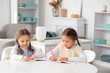 © Pixel-Shot - Cute little girls writing in copybooks at home