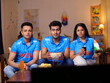 © Knot9 Images - A group of fans in Indian jerseys sitting on a couch and watching a live cricket match on Television - cricket fever. Indian cricket fans are engrossed in checking the live score  fantasy cricket t...