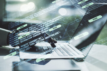 Wall Mural - multi exposure of abstract programming language hologram with hands typing on computer keyboard on b