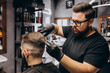 © Petro - Client doing hair cut at a barber shop salon