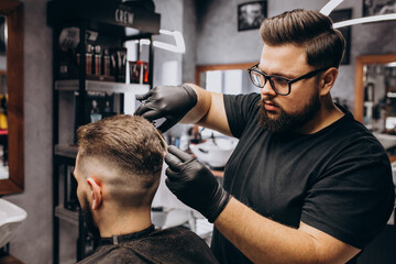 Client doing hair cut at a barber shop salon