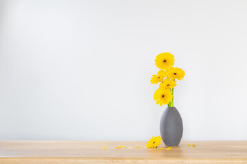 Wall Mural - yellow gerbera in  vase on wooden shelf