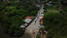 Ascending Drone Footage Of A Row Of Cars Waiting For The Ferry To Cross The River On A Sunny Day