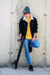 © simona - Standing young boy portrait with casual clothes trendy fashion style against a urban wall with skate board. Concept of youth teen lifestyle. Modern generation people posing for picture. Model.