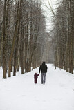 Fototapeta Miasto - Happy family playing and laughing in winter outdoors in the snow. City park winter day.
