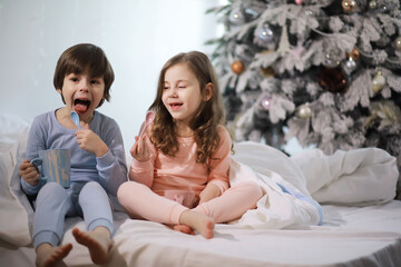 A family with children having fun on the bed under the covers during the Christmas holidays.