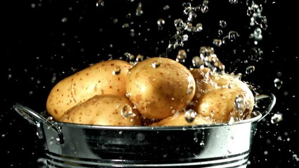 Poster - Drops of water fall on potatoes in a bucket. Filmed on a high-speed camera at 1000 fps. High quality FullHD footage