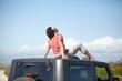 © Marine Gastineau/peopleimages.com - Travel, man and sitting on van roof for scenery, nature and fresh air on adventure or vacation in South Africa. Person, tourist or traveler on rooftop of car with sunglasses for view or road trip