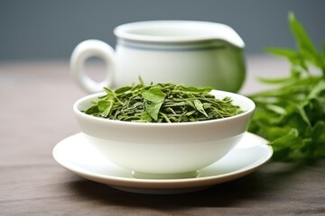 Poster - green tea leaves in a white ceramic cup