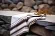 brown and cream tallit on a stone surface