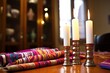 unlit shabbat candles with a torah and prayer shawl in the background
