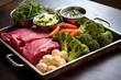 raw vegetables and meat for a barbecue on a metal tray