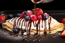crepe drizzled with syrup and filled with berries