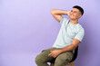 © luismolinero - Young man sitting on a chair over isolated background thinking an idea