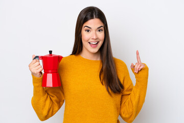 Wall Mural - Young Brazilian woman holding coffee pot isolated on white background pointing up a great idea