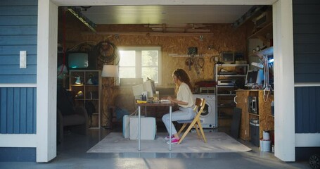 Fototapete - Hispanic Female Software Engineer Programming On Old Desktop Computer In Retro Garage With Random Appliances. Woman Working On Innovative Online Service Startup Company In Nineties. Nostalgia Concept.