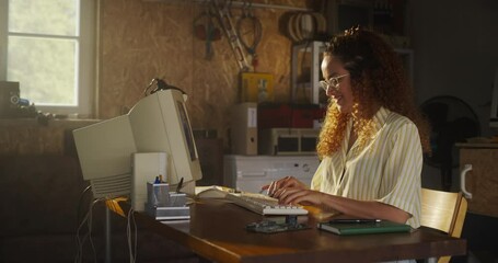 Poster - Hispanic Female Software Engineer Programming On Old Desktop Computer In Retro Garage With Random Appliances. Young Woman Starting Fintech Startup Company In Nineties. Nostalgia Concept. Zoom Out Shot