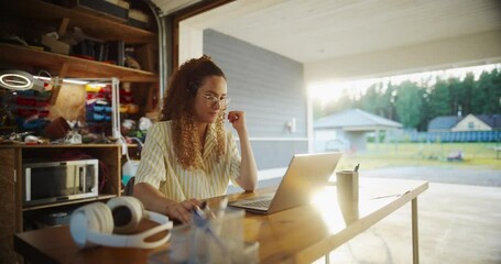 Fototapete - Young Hispanic Female Software Developer Programming On Laptop Computer In Opened Garage. Woman Running A Startup With Innovative SaaS Solution For Businesses. Professional Coding, Optimizing System.