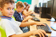 © Robert Kneschke - Boy sitting at desk in computer class