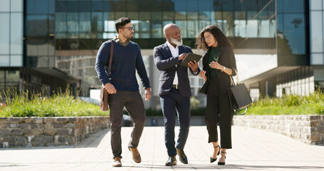 Poster - Walking, talking and business people with a tablet in the city for planning, meeting or discussion. Teamwork, corporate and employees speaking with technology for a strategy, internet or email