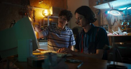 Fototapete - Portrait Of Caucasian Male Tech Startup Founders Using Old Desktop Computer In Retro Garage In The Evening. Software Developer And User Interface Designer Starting New E-commerce Business In Nineties.