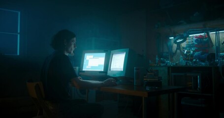 Leinwandbilder - Caucasian Male Programmer Using Old Desktop Computer With Two Monitors In Retro Garage Late At Night. Evil Hacker Searching For Software Vulnerabilities, Coding DDOS Attack, Trojan Horse Program.