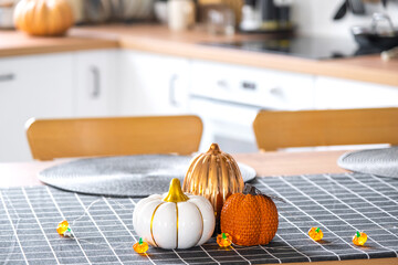 Wall Mural - Decor of white classic kitchen with pumpkins, garlands, latern for Halloween and harvest with figurine of house. Autumn mood in home interior, modern loft style. real estate, insurance, mortgage