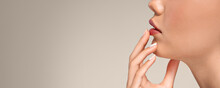 Calm European Young Woman With Perfect Skin Touching Hands To Red Lips
