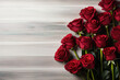 red roses frame on light wooden background top view, beautiful floral template with copy space