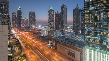 Wall Mural - Business bay district skyline with modern architecture timelapse day to night transition after sunset from above. Aerial panorama of Dubai skyscrapers, towers near main highway. Traffic on crossroad